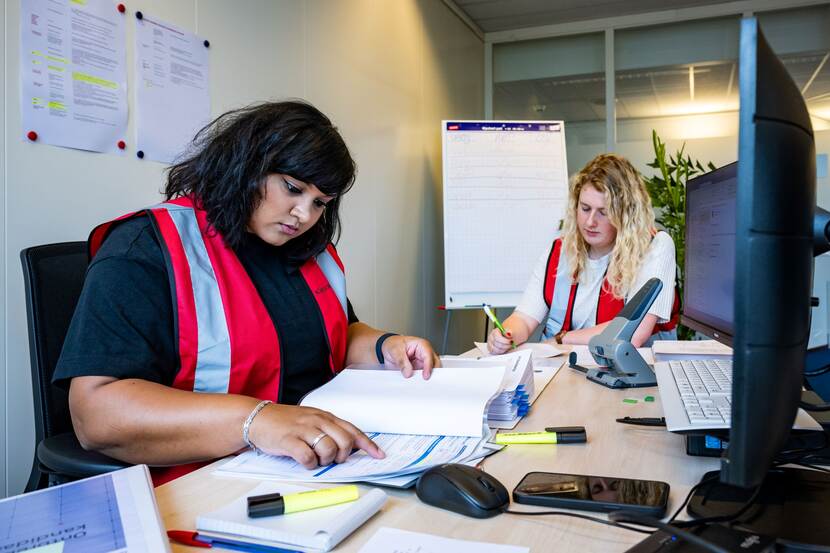 Medewerkers van de Kiesraad controleren documenten die zijn ingeleverd door politieke groeperingen