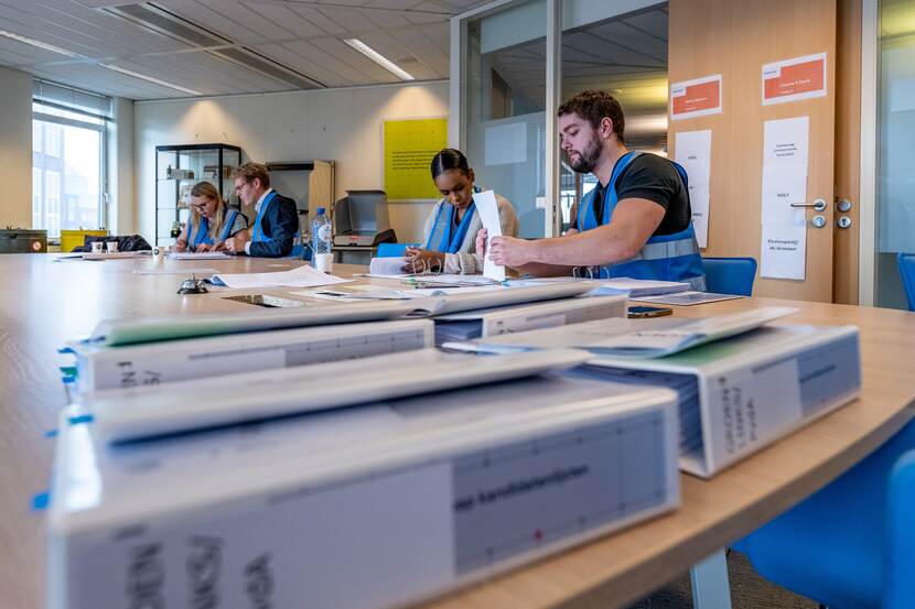 Medewerkers van de Kiesraad controleren de kandidatenlijsten