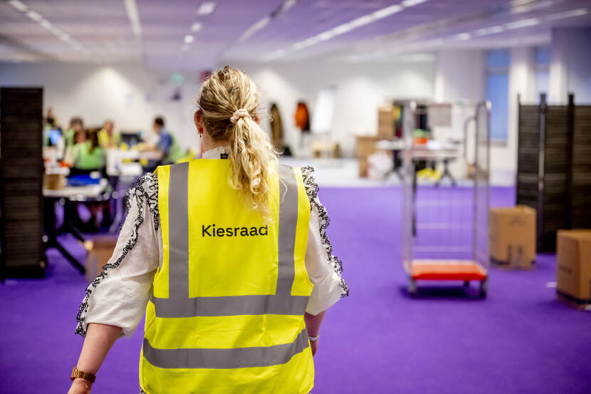 Medewerker Kiesraad draagt een hesje met de tekst Kiesraad