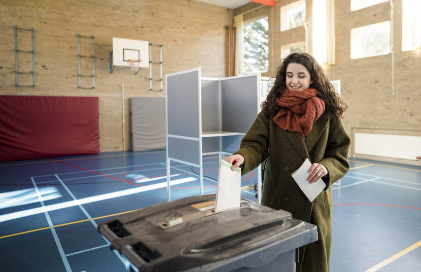 Vrouw doet stembiljet in stembus