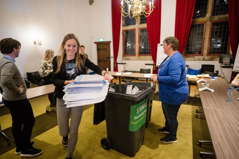 Medewerkers van het stembureau halen de stembiljetten uit de bus om deze te gaan tellen